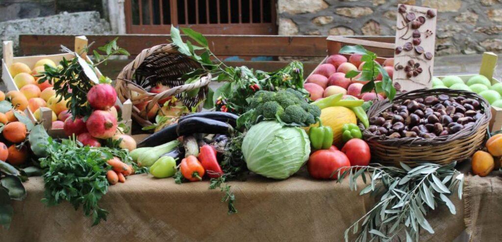 Φρέσκα εποχιακά λαχανικά και φρούτα σε καλάθια που προσφέρουν την αληθινή γεύση της φύσης πάνω σε ένα παραδοσιακό τραπέζι.