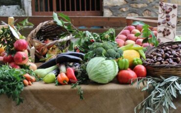 Φρέσκα εποχιακά λαχανικά και φρούτα σε καλάθια που προσφέρουν την αληθινή γεύση της φύσης πάνω σε ένα παραδοσιακό τραπέζι.