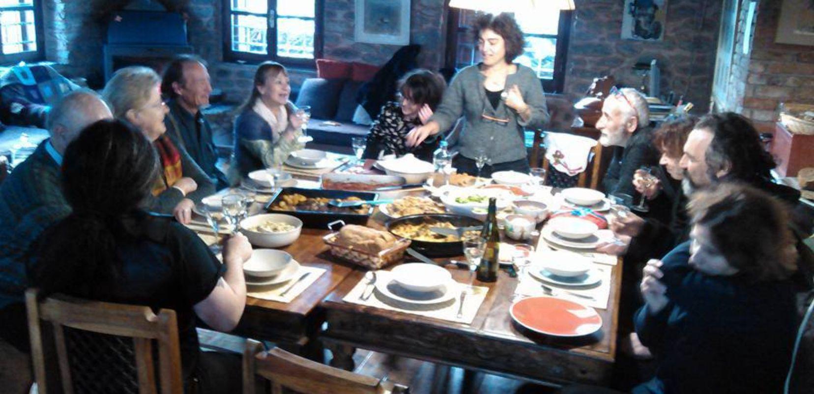 Ένα τραπέζι γεμάτο πιάτα με φαγητό καμμία παρέα που συζητάει